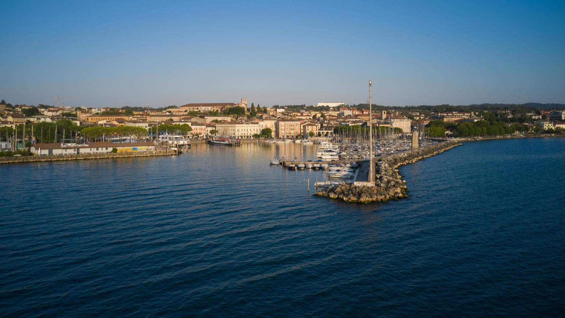 Tourist harbor with boats and city view at sunset.