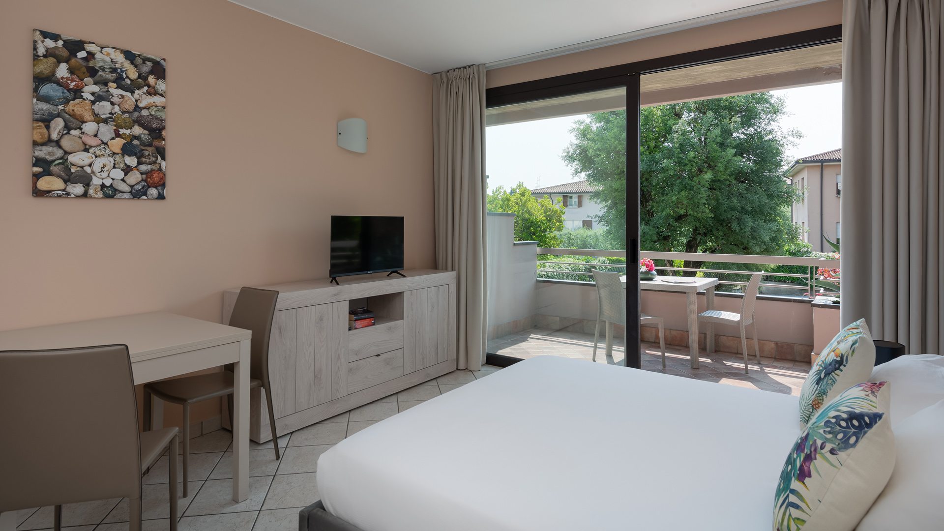 Bright room with balcony, TV, and natural decorations.