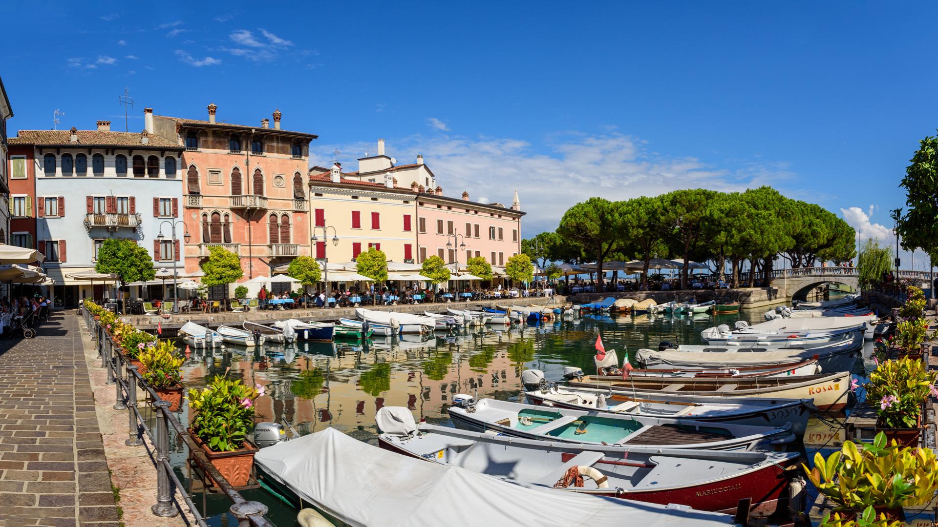 Porticciolo pittoresco con barche e architettura colorata in una giornata di sole.