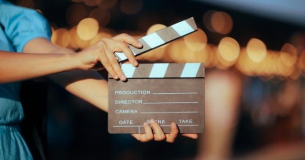 A person holds a film clapperboard ready for action.