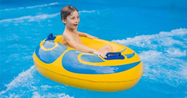 Child enjoying a yellow inflatable raft in the pool.