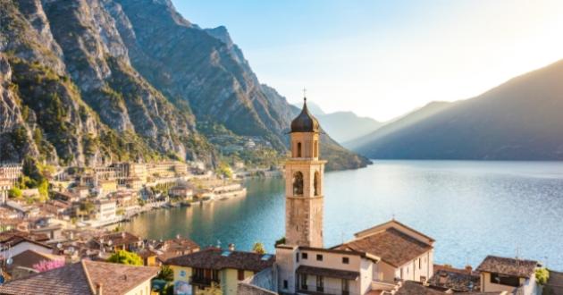 Breathtaking view of an alpine lake with a bell tower and mountains.