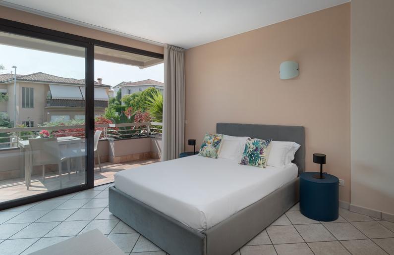 Modern room with a double bed and balcony overlooking the garden.