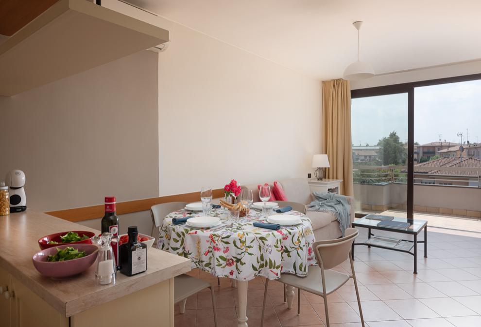 Bright living room with sofa, dining table, and balcony access.