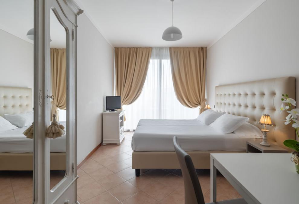 Modern bedroom with double bed, TV, and bedside lamps.